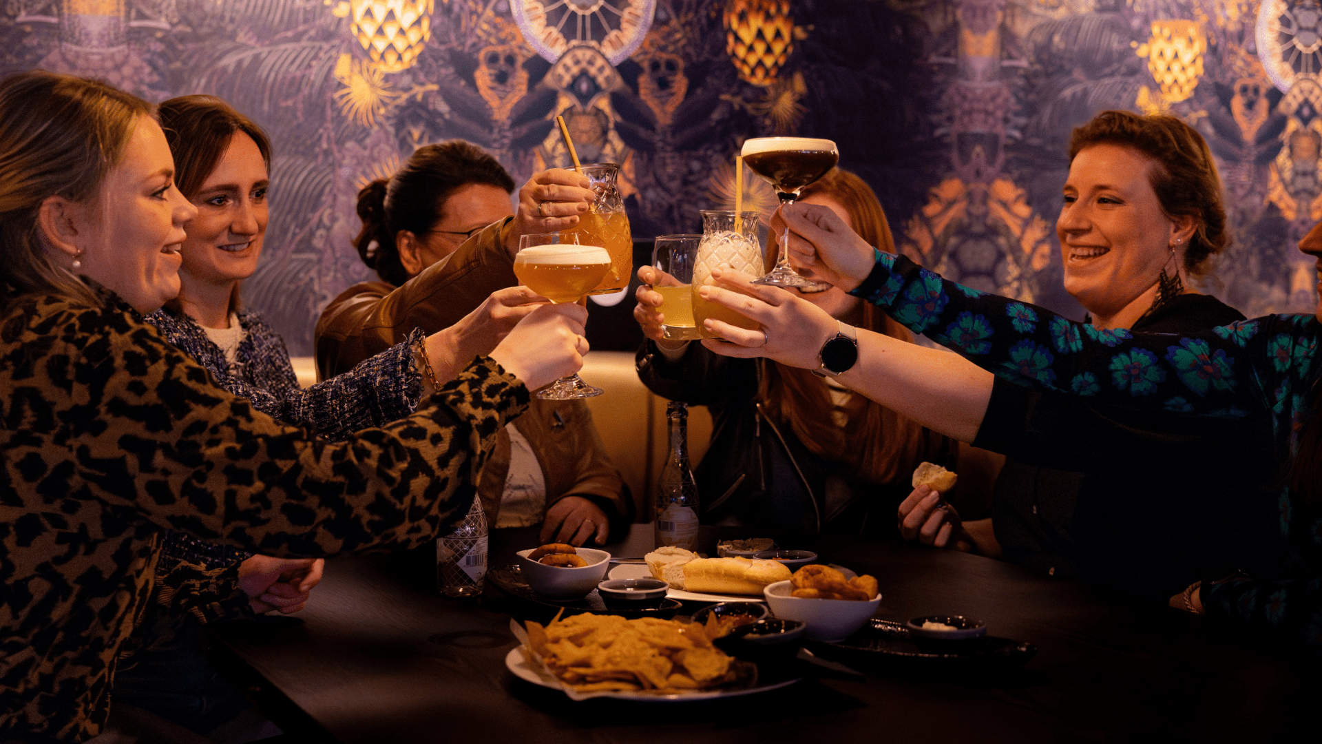 mensen die gezellig samen een cocktail drinken en proosten en wat eten